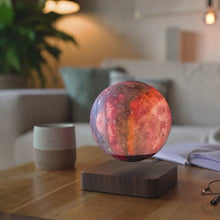 Load and play video in Gallery viewer, Videoen viser Kosmos-lampen i action, hvor den svæver og roterer over sin magnetiske base. Det viser også den detaljerede udsmykning af planeter og stjerner, samt det justerbare lysstyrkeniveau. Oplev den betagende atmosfære og den unikke dekorationsidé, som Kosmos-lampen tilføjer til ethvert rum.